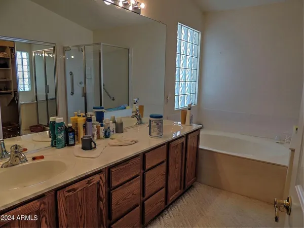 a bathroom with double vanity sinks double vanity tub and a mirror