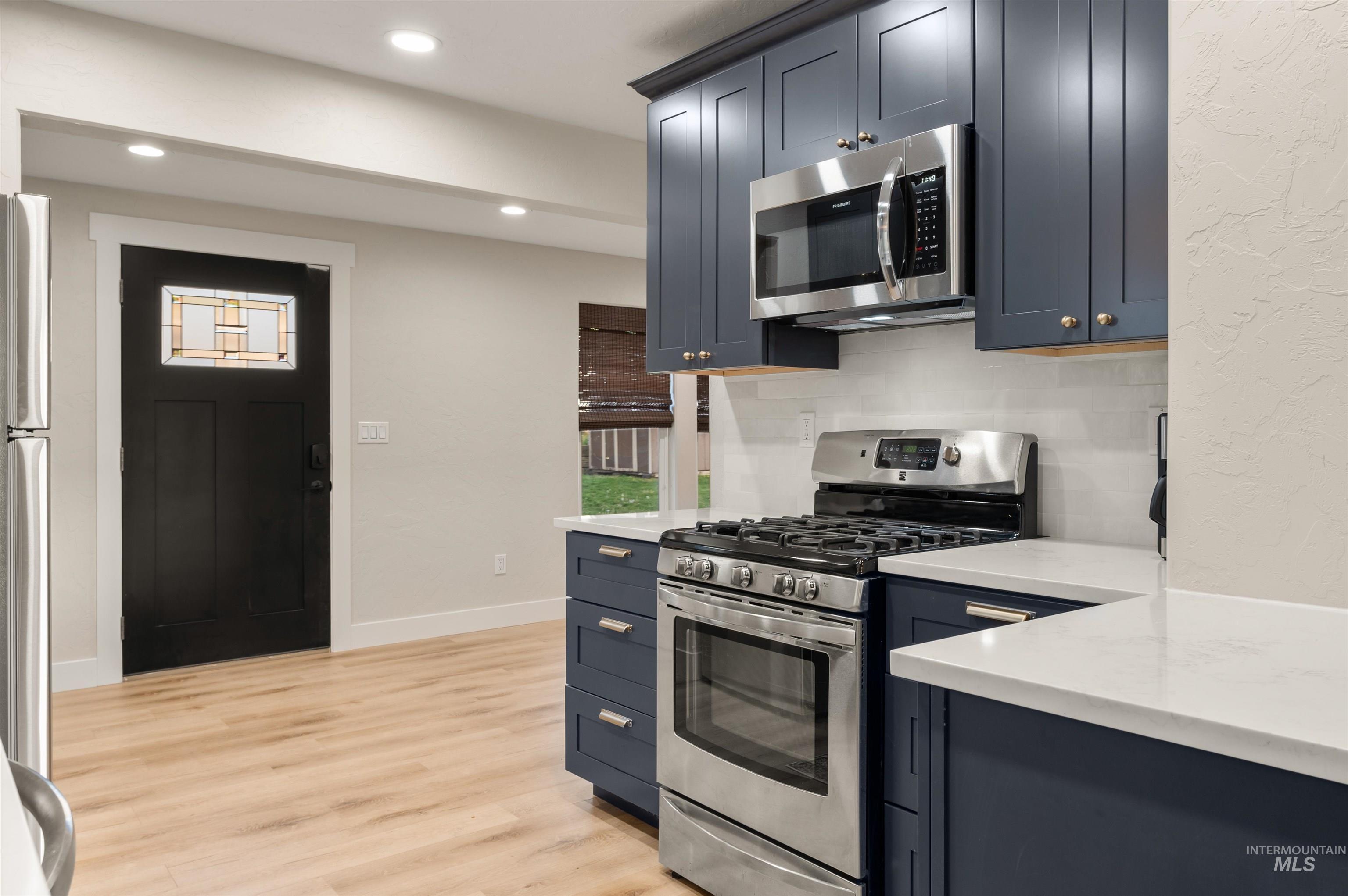 811 Prospect Avenue Lewiston, ID 83501 - Photo 9 of 23 Open-concept dining area featuring wood-finish flooring, a contemporary chandelier, and a five-panel interior door with matte black hardware