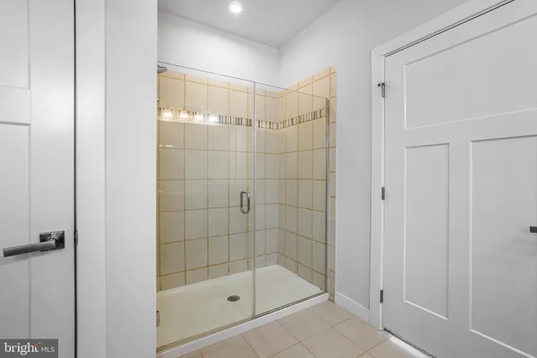 an empty room with chandelier fan and windows