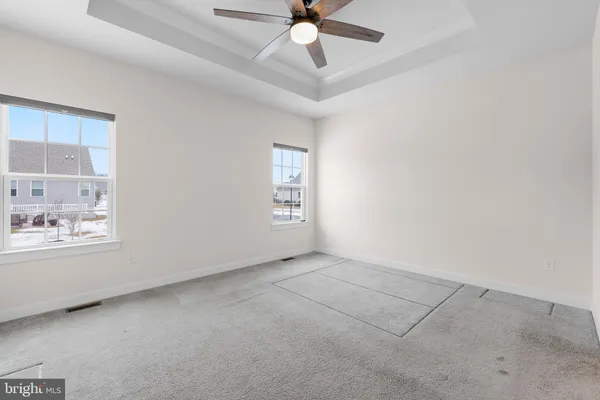 an empty room with a ceiling fan and a window