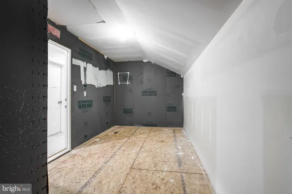 an empty room with chandelier fan and windows