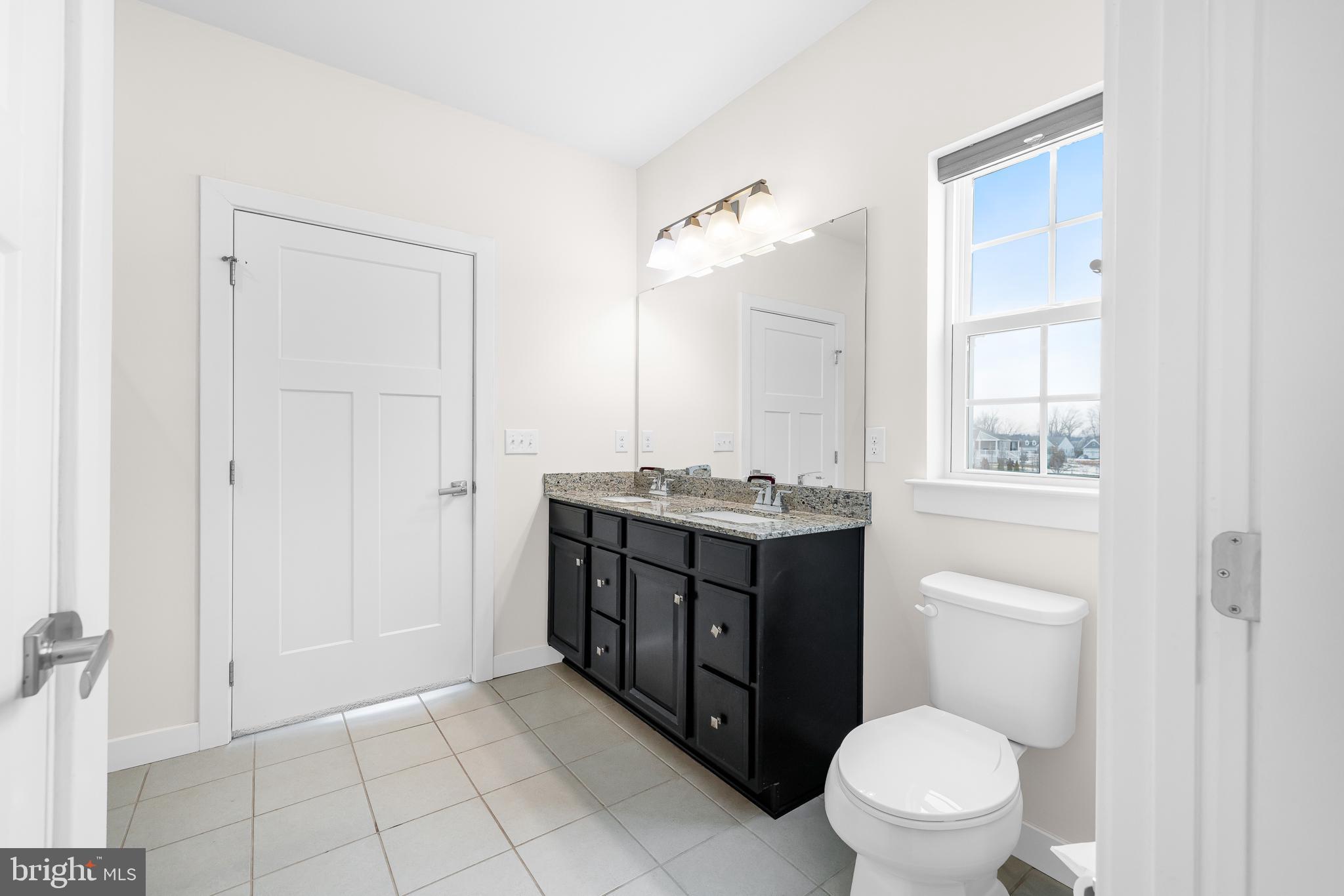929 Robinson Road Townsend, DE 19734 - Photo 37 of 57 a bathroom with a granite countertop toilet a sink and a mirror