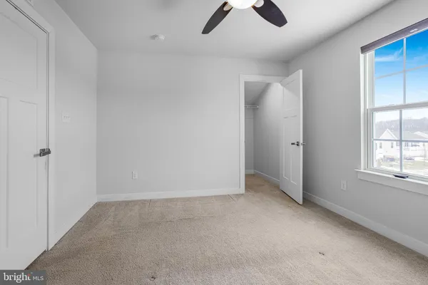 an empty room with closet and windows
