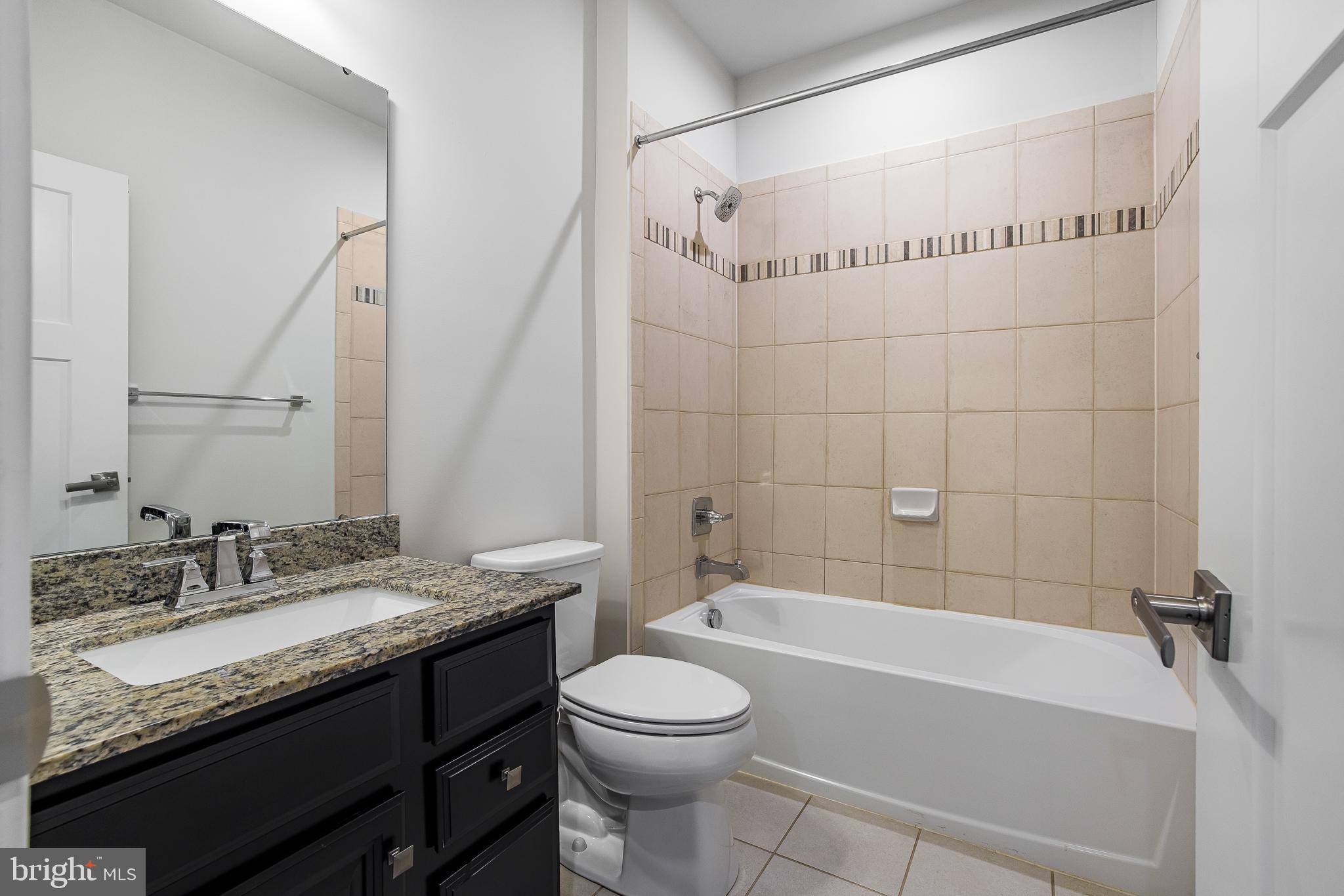 929 Robinson Road Townsend, DE 19734 - Photo 42 of 57 a bathroom with a granite countertop sink a toilet and bathtub