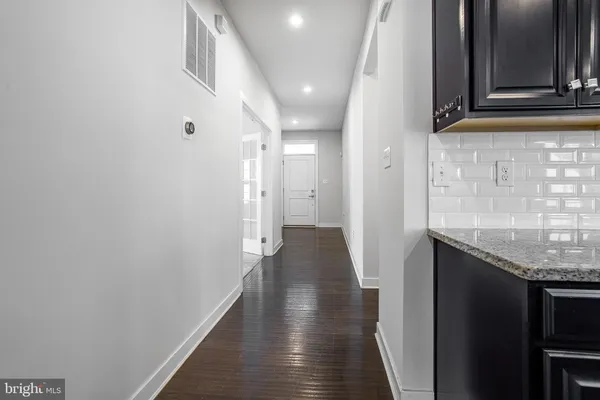 a view of hallway with stairs and wooden floor