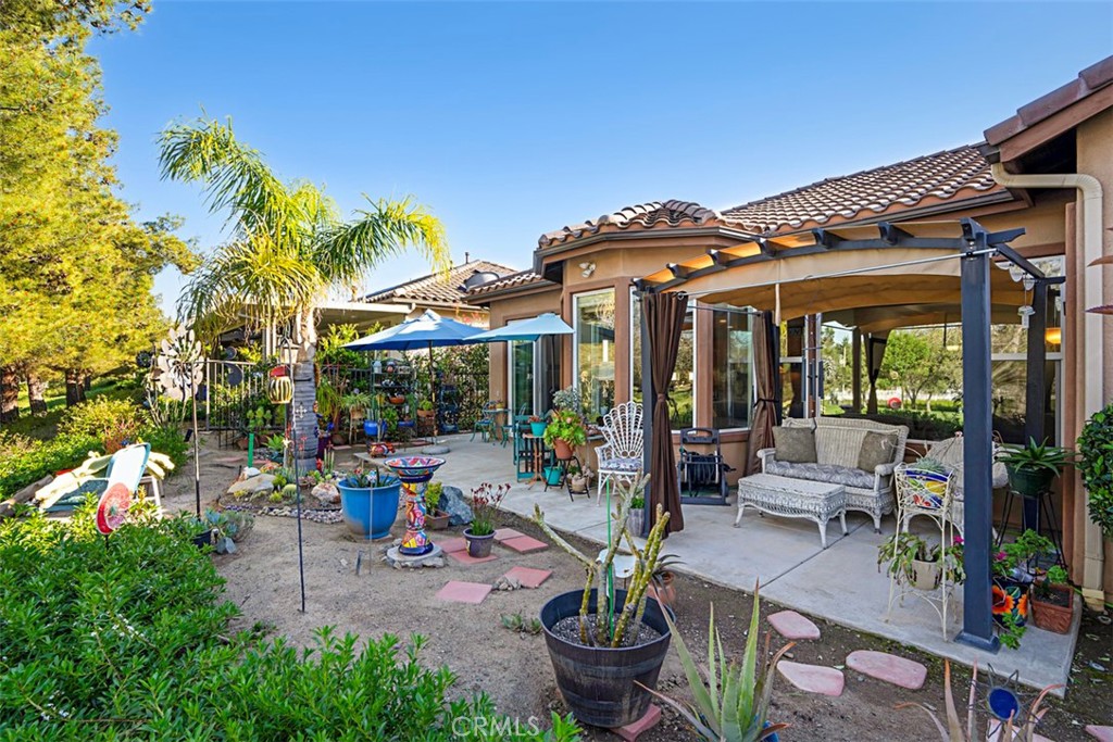 23858 Kaleb Drive Corona, CA 92883 - Photo 15 of 45 a view of a patio with table and chairs potted plants and palm trees