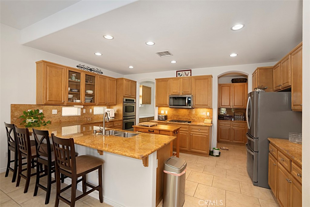 23858 Kaleb Drive Corona, CA 92883 - Photo 4 of 45 a kitchen with refrigerator and chairs
