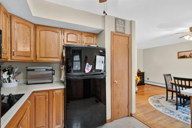 a kitchen with stainless steel appliances granite countertop a refrigerator a stove top oven and a dining table