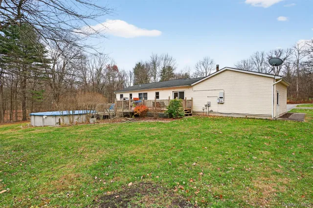 a view of a backyard with plants and large trees