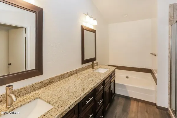 a bathroom with a granite countertop sink and a bathtub