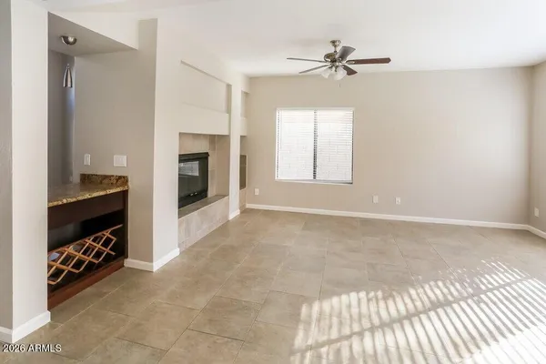 a view of an empty room with a ceiling fan and a window