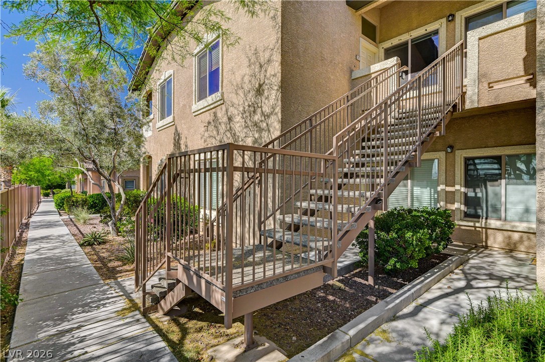 8985 South Durango Drive, Unit 2187 Las Vegas, NV 89113 - Photo 10 of 73 A well-maintained stucco exterior features metal staircases leading to upper-level units, surrounded by desert-adapted landscaping.