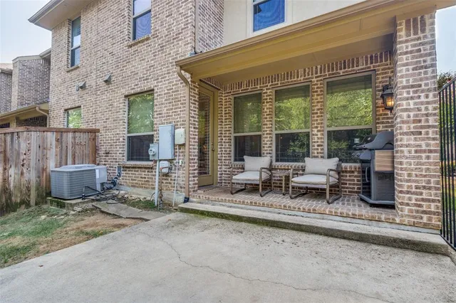 a view of a patio with table and chairs and wooden fence