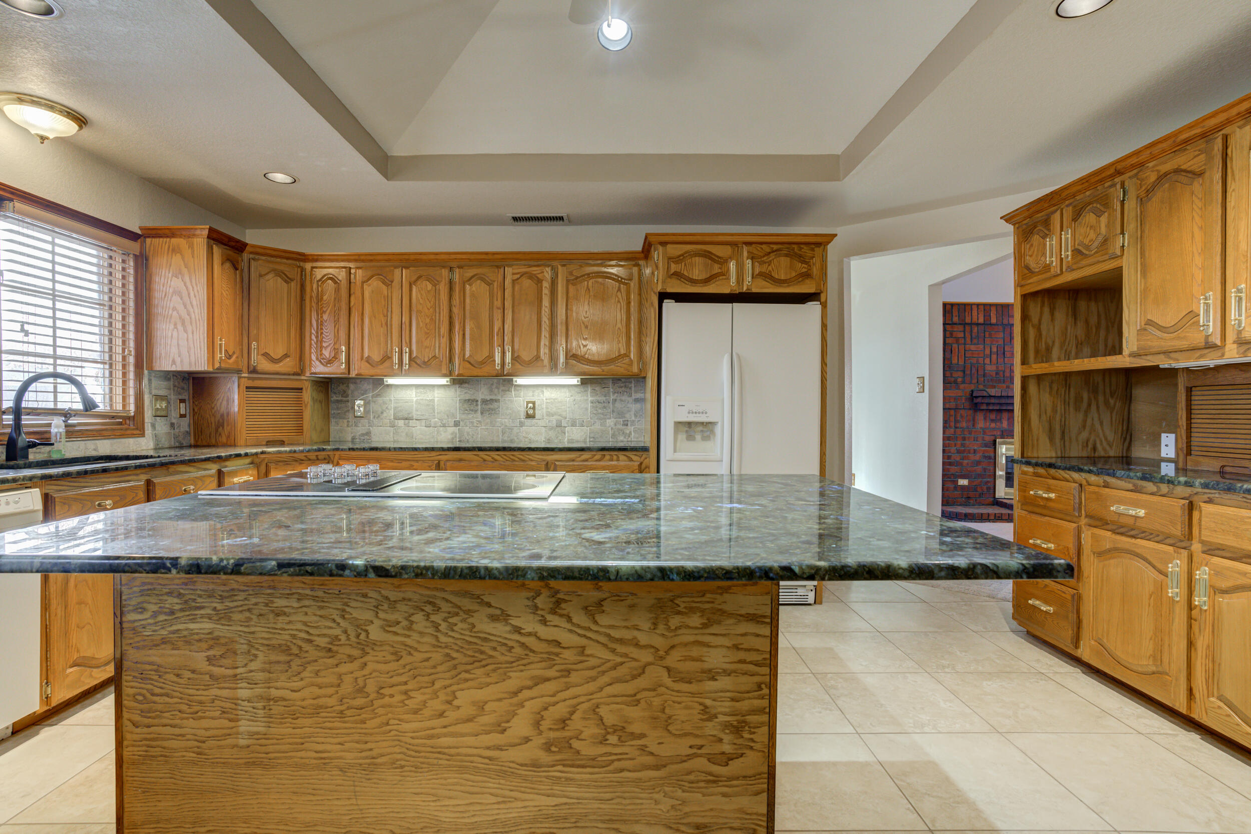 801 19th Street Seagraves, TX 79359 - Photo 13 of 24 a kitchen with granite countertop a sink a stove and cabinets