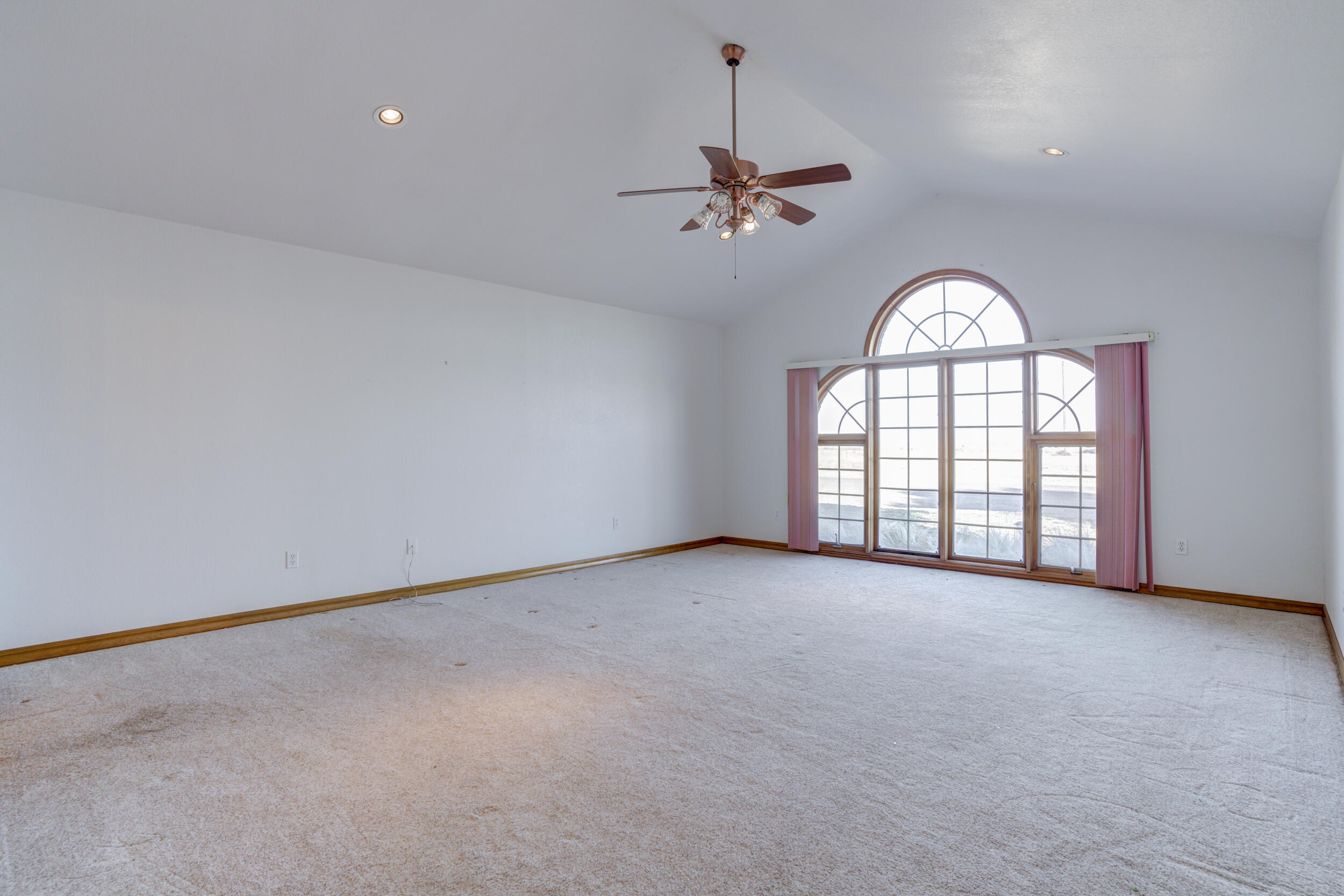801 19th Street Seagraves, TX 79359 - Photo 17 of 24 an empty room with windows and chandelier fan