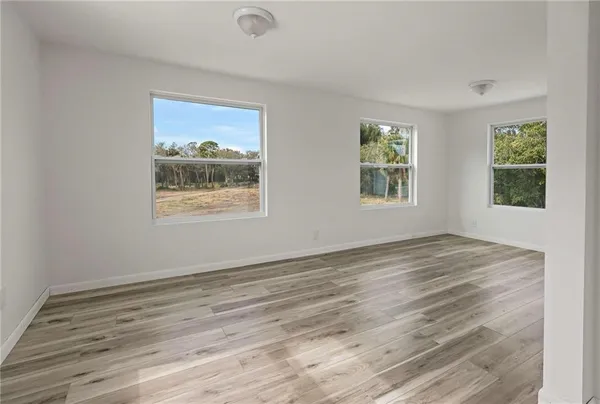 a kitchen with stainless steel appliances granite countertop a refrigerator a stove and white cabinets with wooden floor