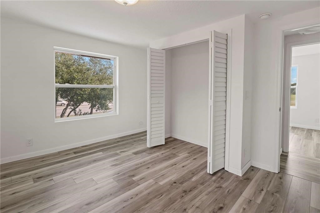 9185 Highway 1 Sebastian, FL 32958 - Photo 17 of 30 an empty room with wooden floor and windows