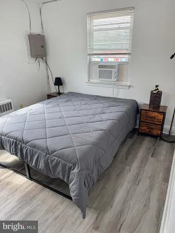 a bedroom with a bed and wooden floor