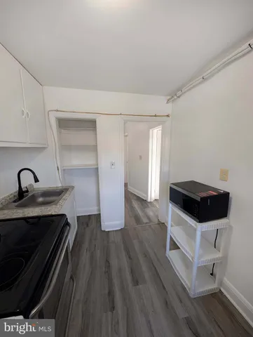 a kitchen with granite countertop a stove a sink and a refrigerator