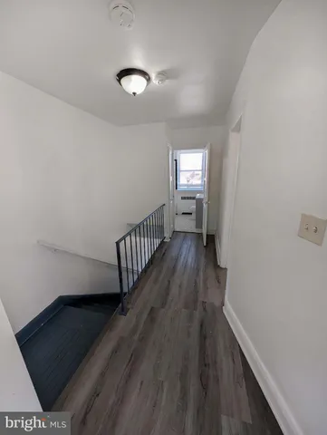 a view of a hallway with wooden floor and a window