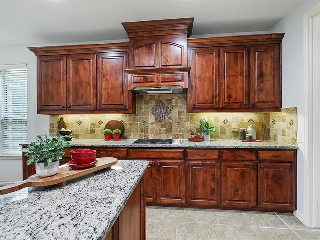 a kitchen with granite countertop a sink and wooden cabinets
