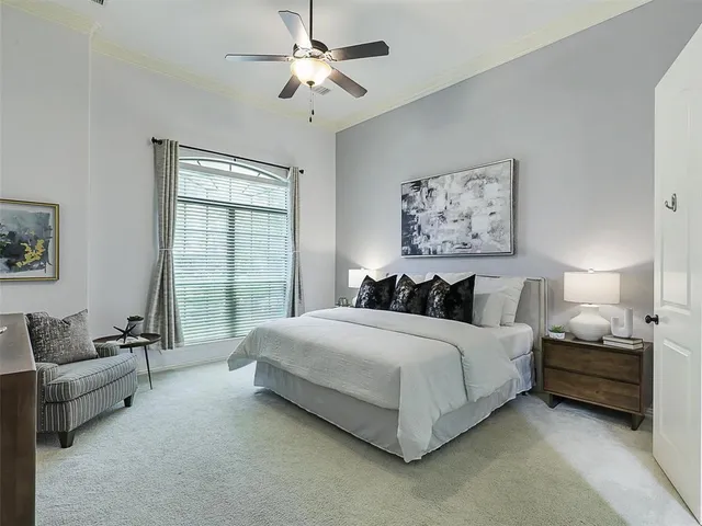 a spacious bedroom with a bed a couch and a window