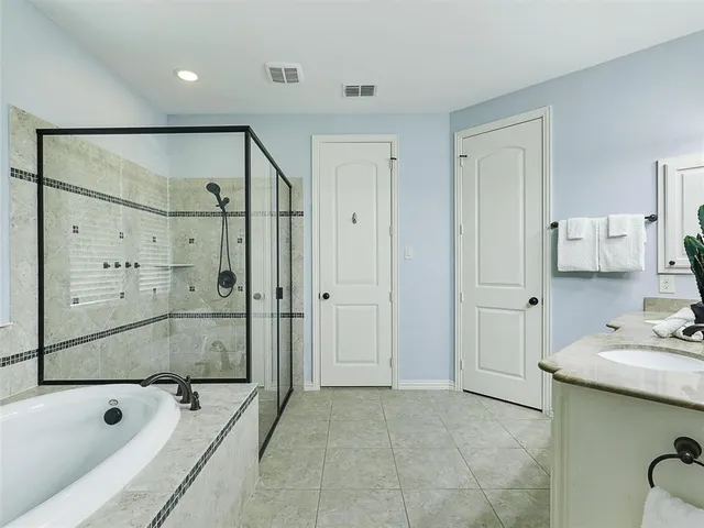 a bathroom with a tub mirror and shower