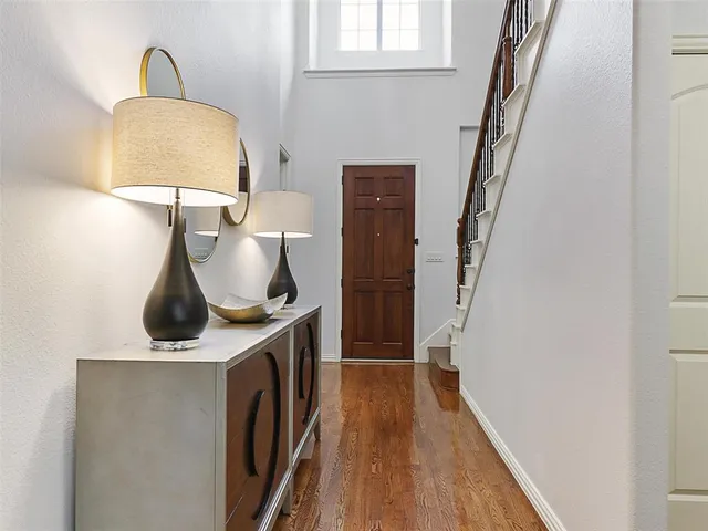 a view of a hallway with wooden floor and staircase