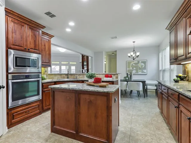a kitchen with kitchen island a sink and a stove top oven