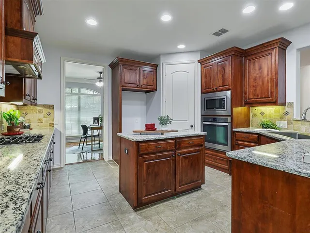 a kitchen with stainless steel appliances granite countertop a stove a sink and a refrigerator