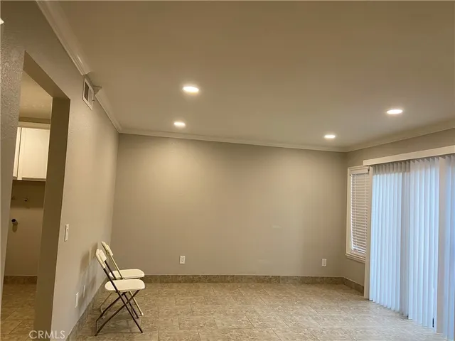 an empty room with wooden floor chandelier fan and windows