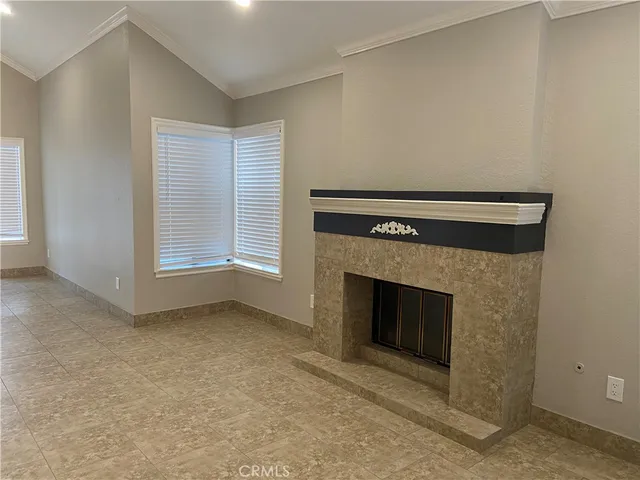 an empty room with windows dryer and fireplace