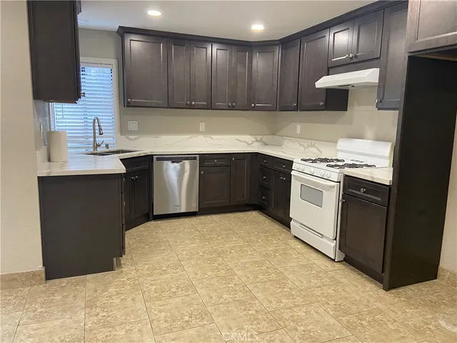 a kitchen with stainless steel appliances granite countertop a stove a sink and a refrigerator