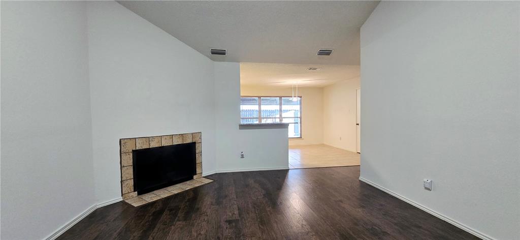 2224 Limestone Lane Garland, TX 75040 - Photo 3 of 5 an empty room with wooden floor and fireplace