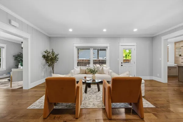 a kitchen with stainless steel appliances a refrigerator a sink dishwasher a stove and a dining table with wooden floor