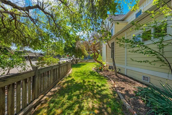 a view of a backyard with table and chairs and wooden fence