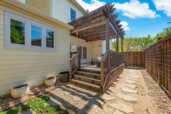 a view of backyard with wooden fence and a large tree