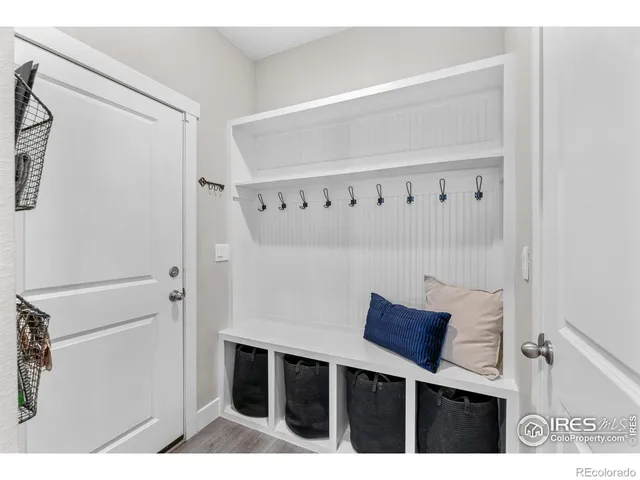 a kitchen with stainless steel appliances granite countertop a sink a stove a refrigerator and white cabinets with wooden floor