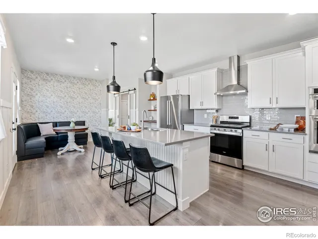 a open kitchen with stainless steel appliances kitchen island granite countertop a stove a sink a dining table and chairs