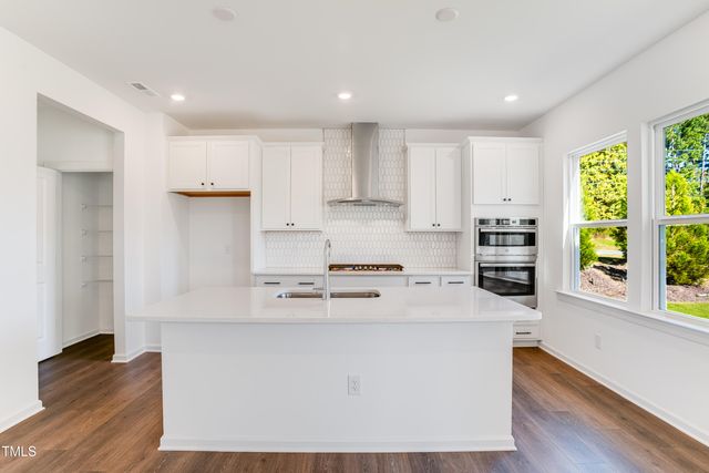 a kitchen with stainless steel appliances a refrigerator and a stove top oven