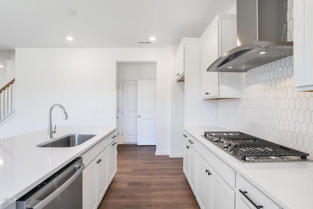 a kitchen with stainless steel appliances a sink a stove and cabinets