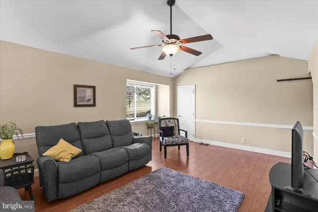 a living room with furniture wooden floor and a window