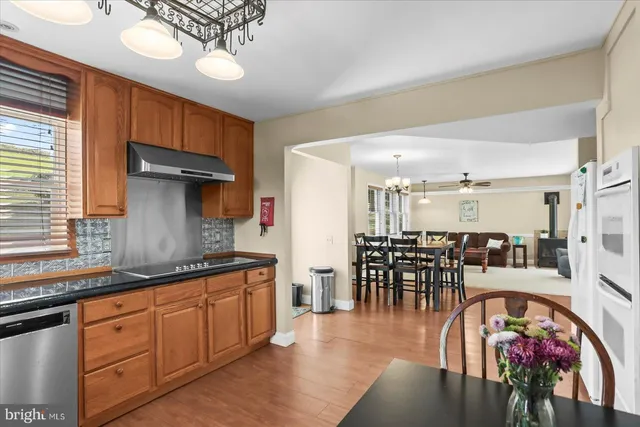 a dining room with wooden floor a chandelier a wooden table and chairs