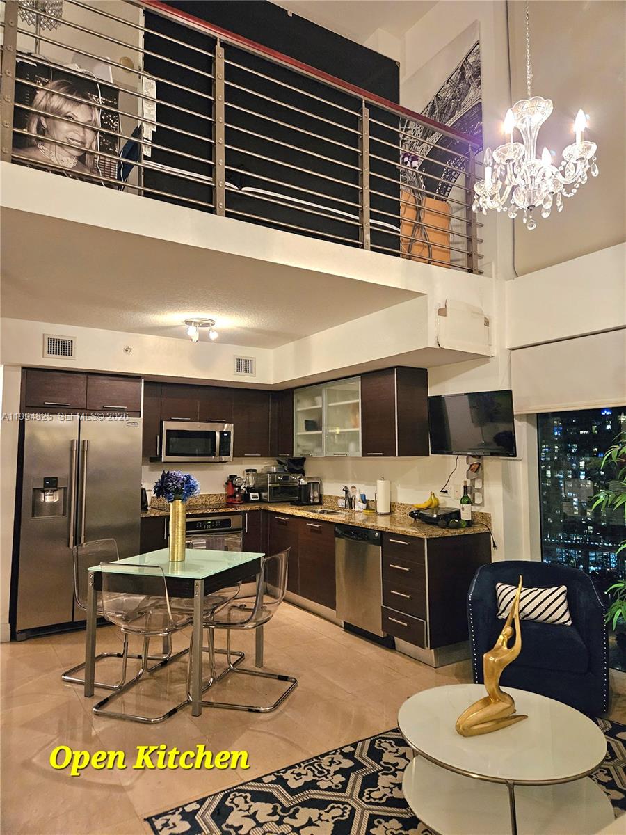 41 Southeast 5th Street, Unit 1517 Miami, FL 33131 - Photo 17 of 62 a kitchen with stainless steel appliances granite countertop a stove and a sink