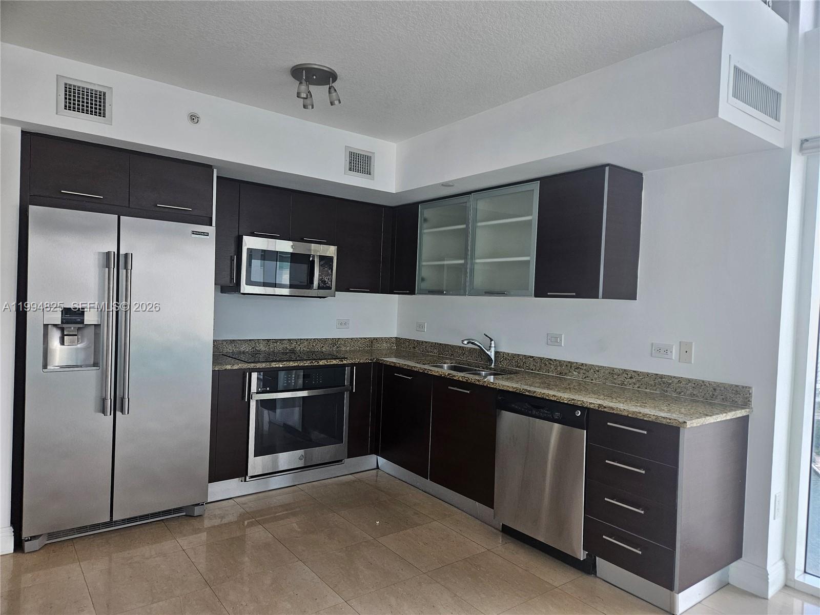 41 Southeast 5th Street, Unit 1517 Miami, FL 33131 - Photo 19 of 62 a kitchen with a sink and stainless steel appliances