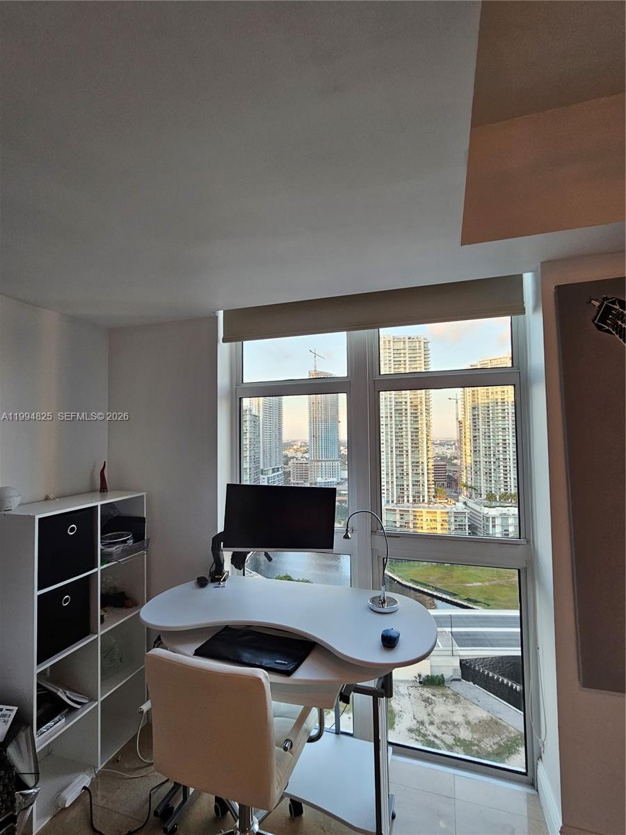 41 Southeast 5th Street, Unit 1517 Miami, FL 33131 - Photo 26 of 62 a living room with furniture a flat screen tv and floor to ceiling window