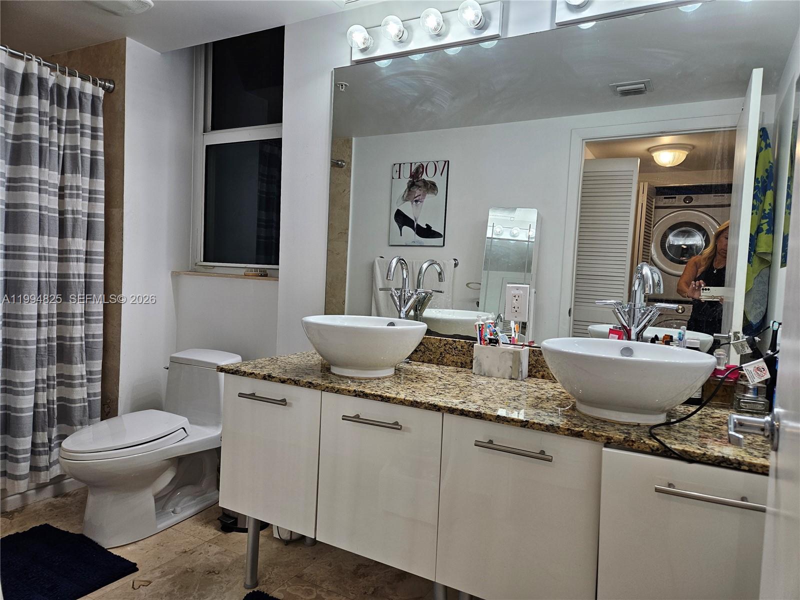 41 Southeast 5th Street, Unit 1517 Miami, FL 33131 - Photo 33 of 62 a bathroom with a granite countertop sink a toilet and a mirror