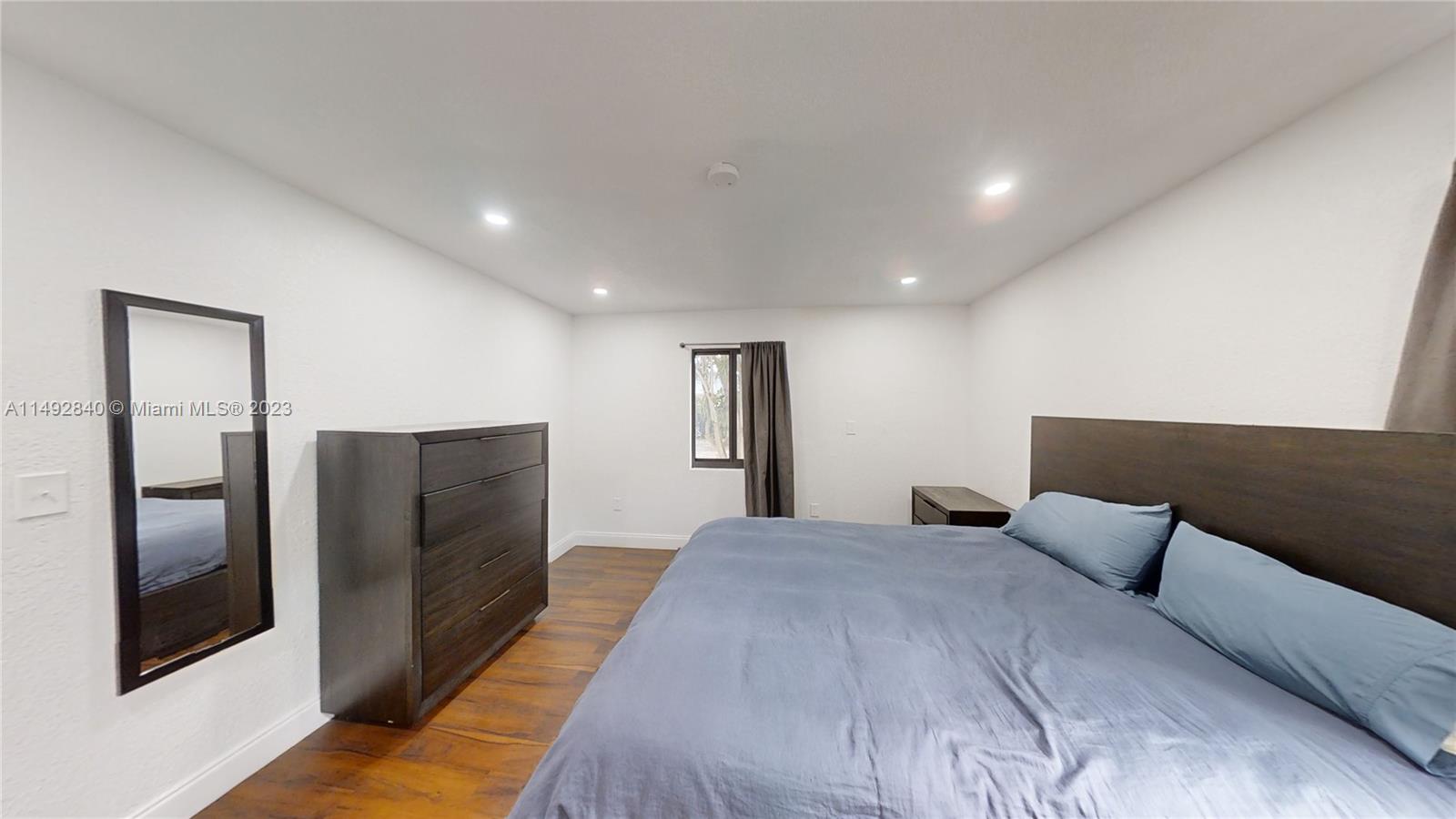 445 Southwest 62nd Court Miami, FL 33144 - Photo 20 of 49 a large bedroom with bed and wooden floor