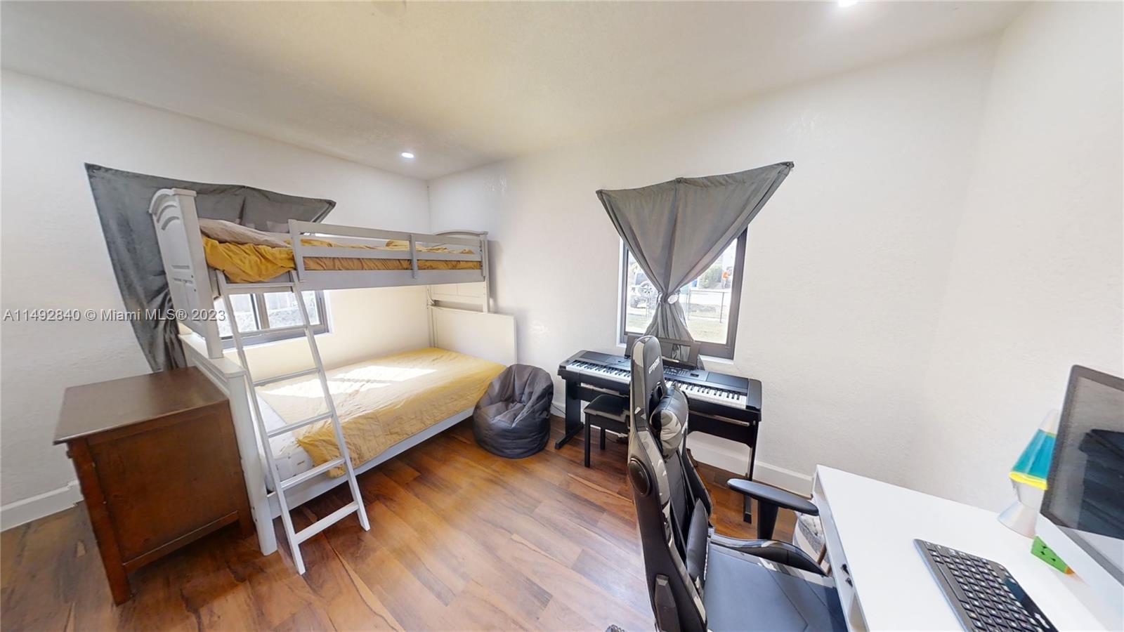 445 Southwest 62nd Court Miami, FL 33144 - Photo 36 of 49 a bedroom with a bed and wooden floor