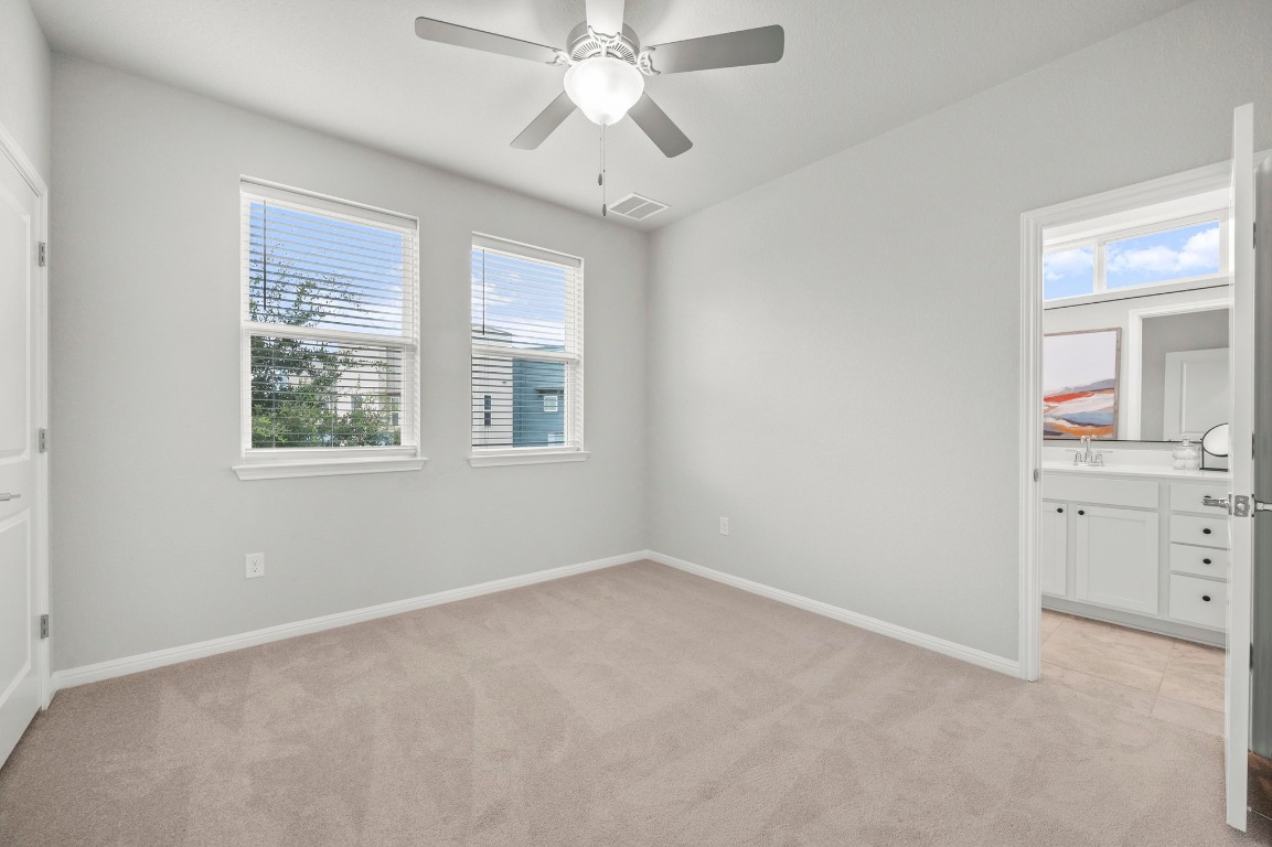 9015 Cattle Baron Path, Unit 2005 Austin, TX 78747 - Photo 22 of 37 an empty room with a chandelier fan and windows